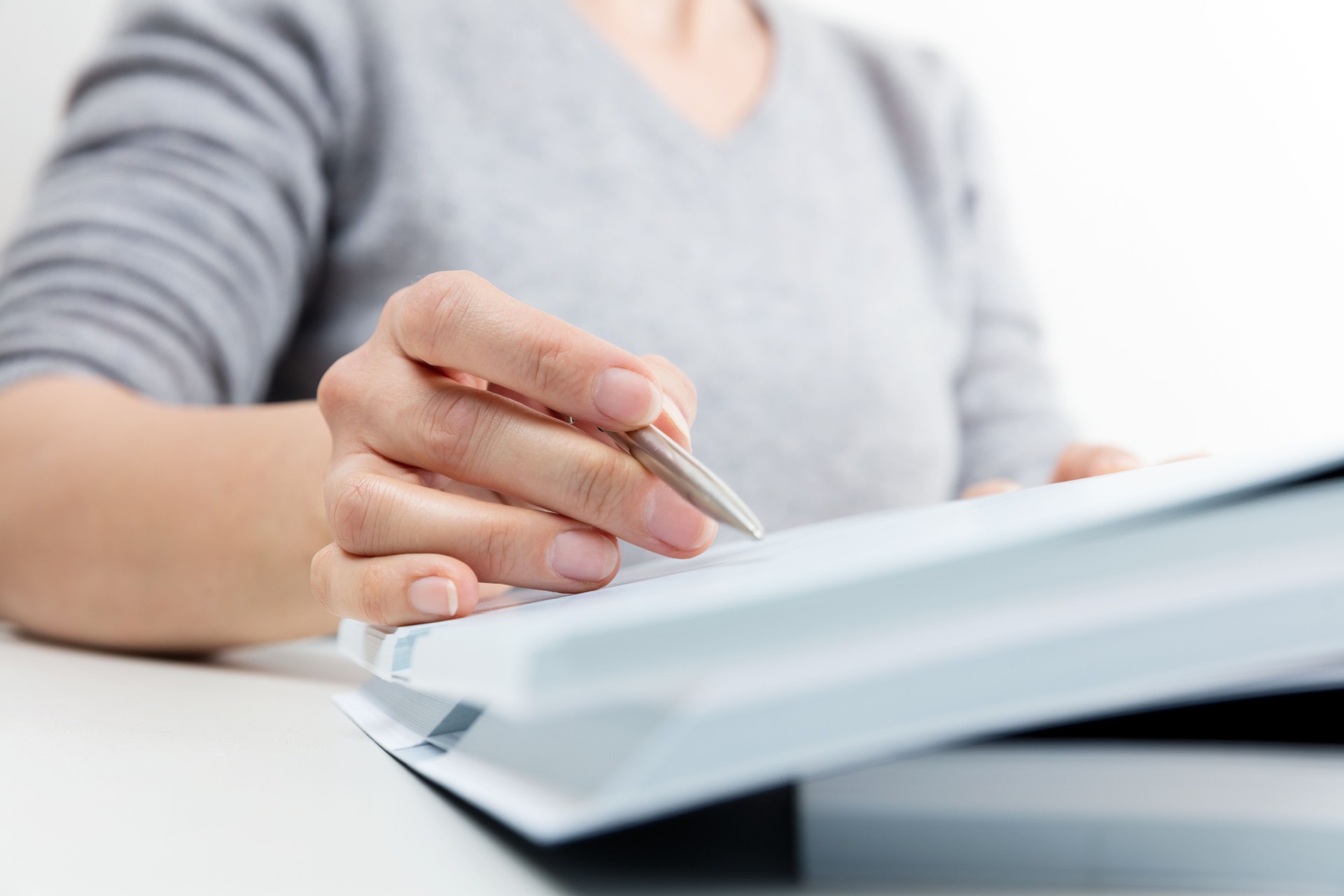 Woman reading, pen showing text in a book